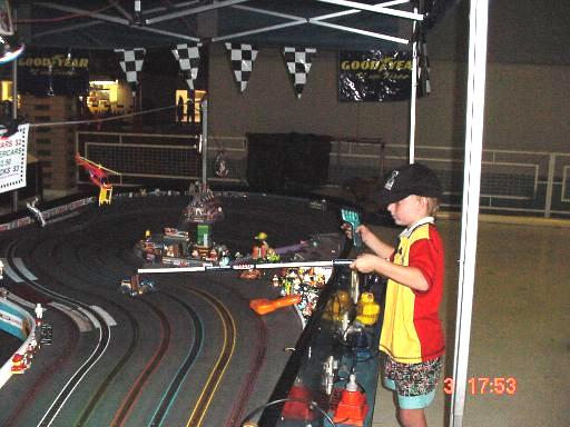 Leo playing on the slot car track, recovering his car after a crash